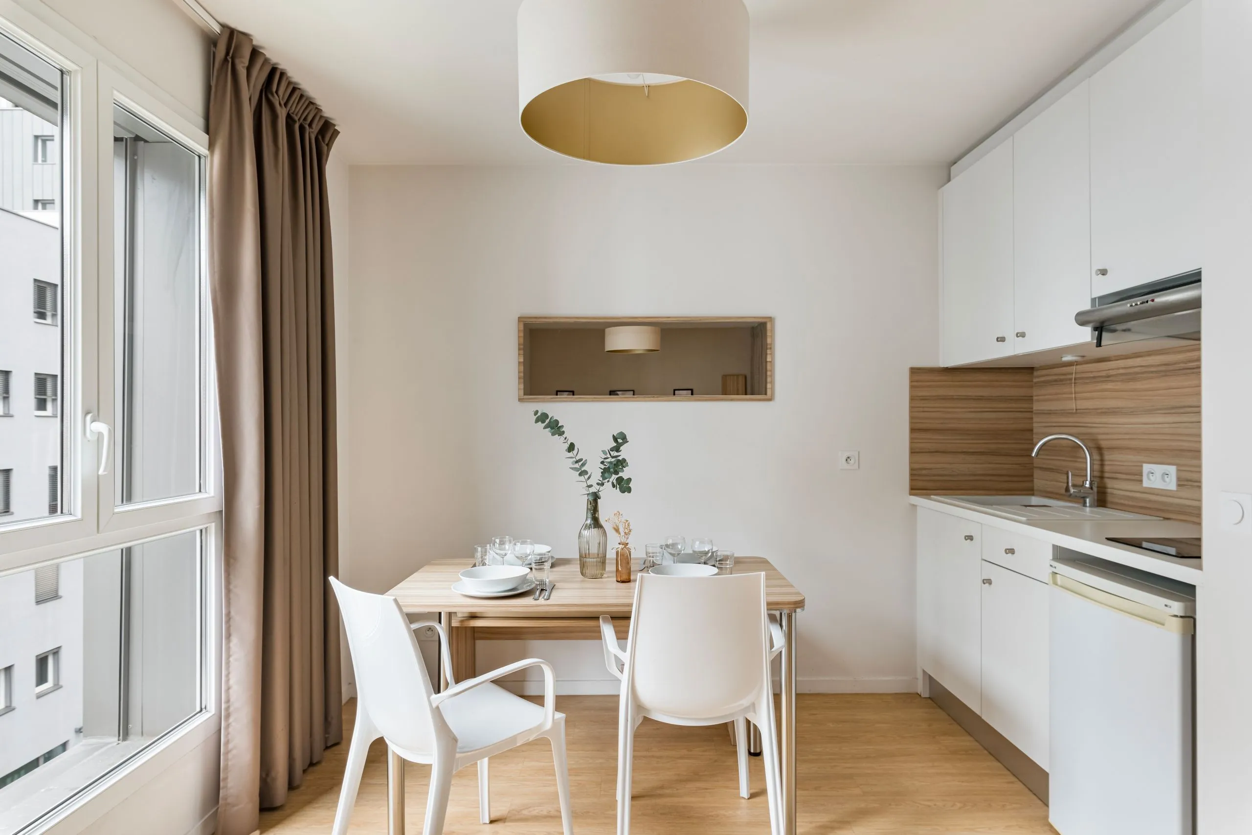 Cuisine moderne avec table en bois et chaises blanches 