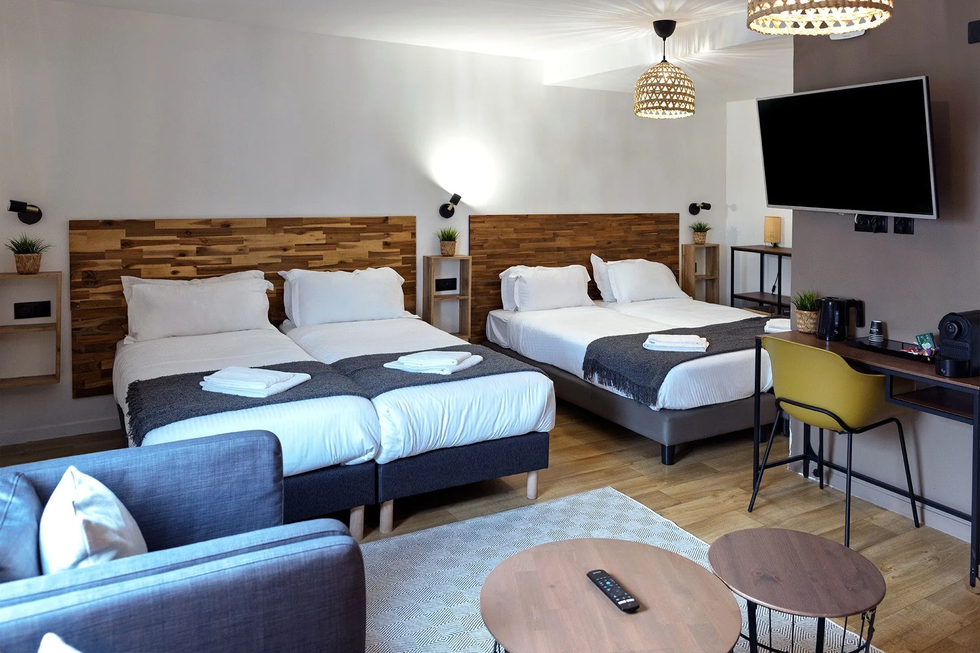 Chambre d'hôtel moderne avec lits doubles et téléviseur 