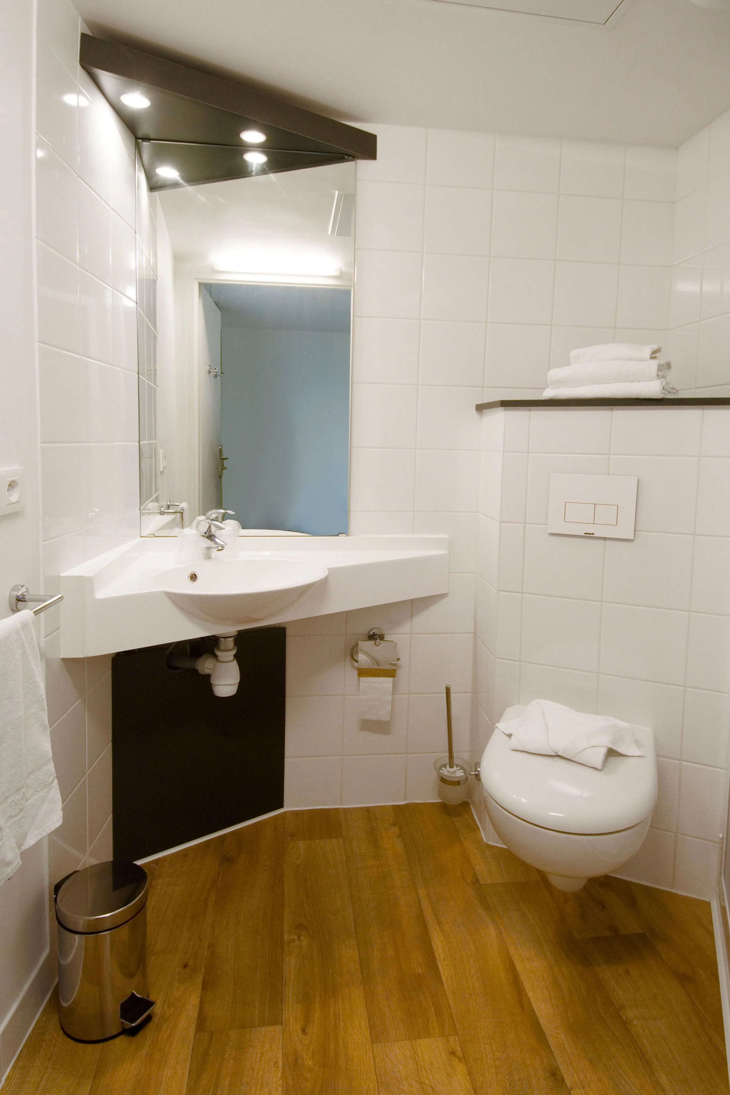 Salle de bain moderne avec parquet et lavabo blanc 