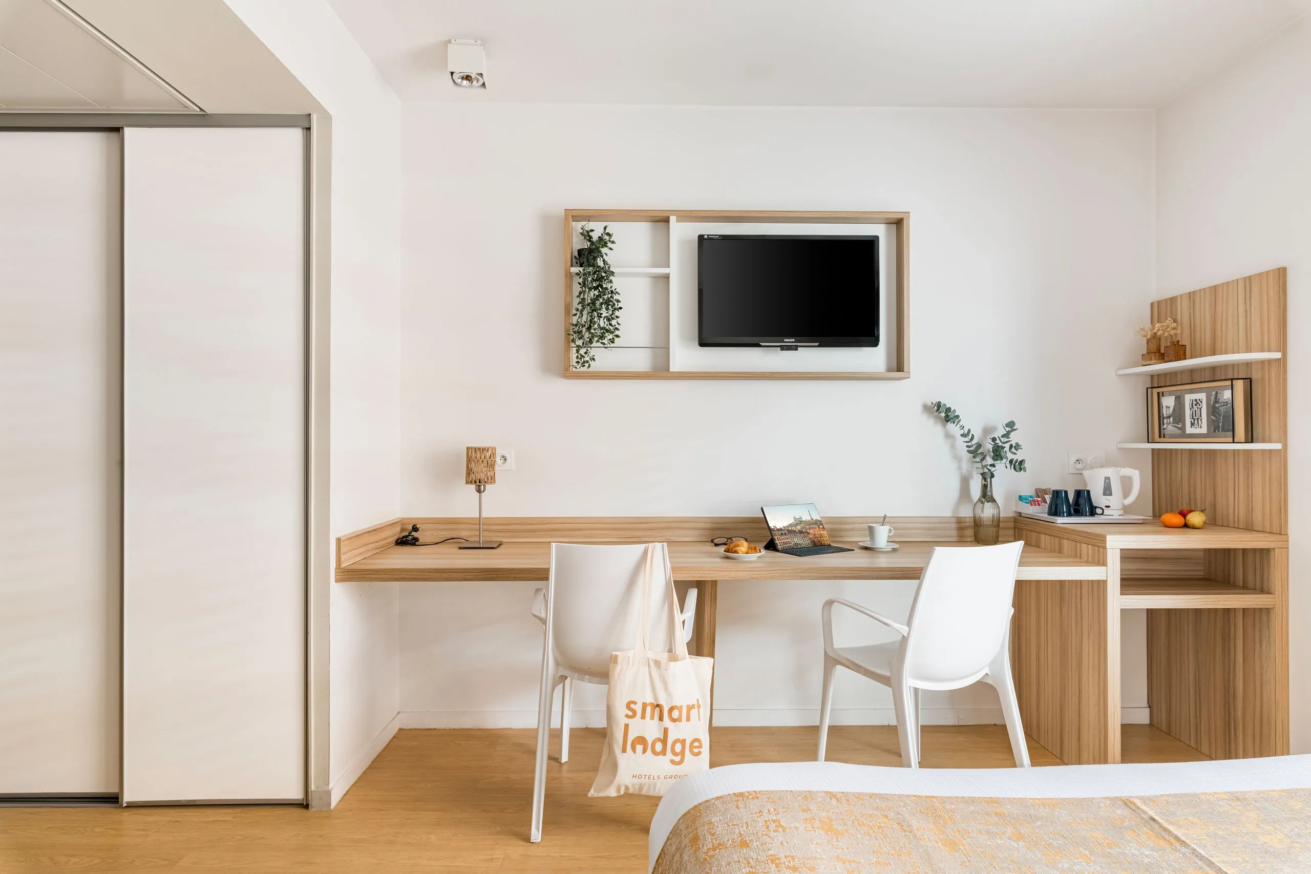 Chambre d'hôtel moderne avec bureau et télévision murale 