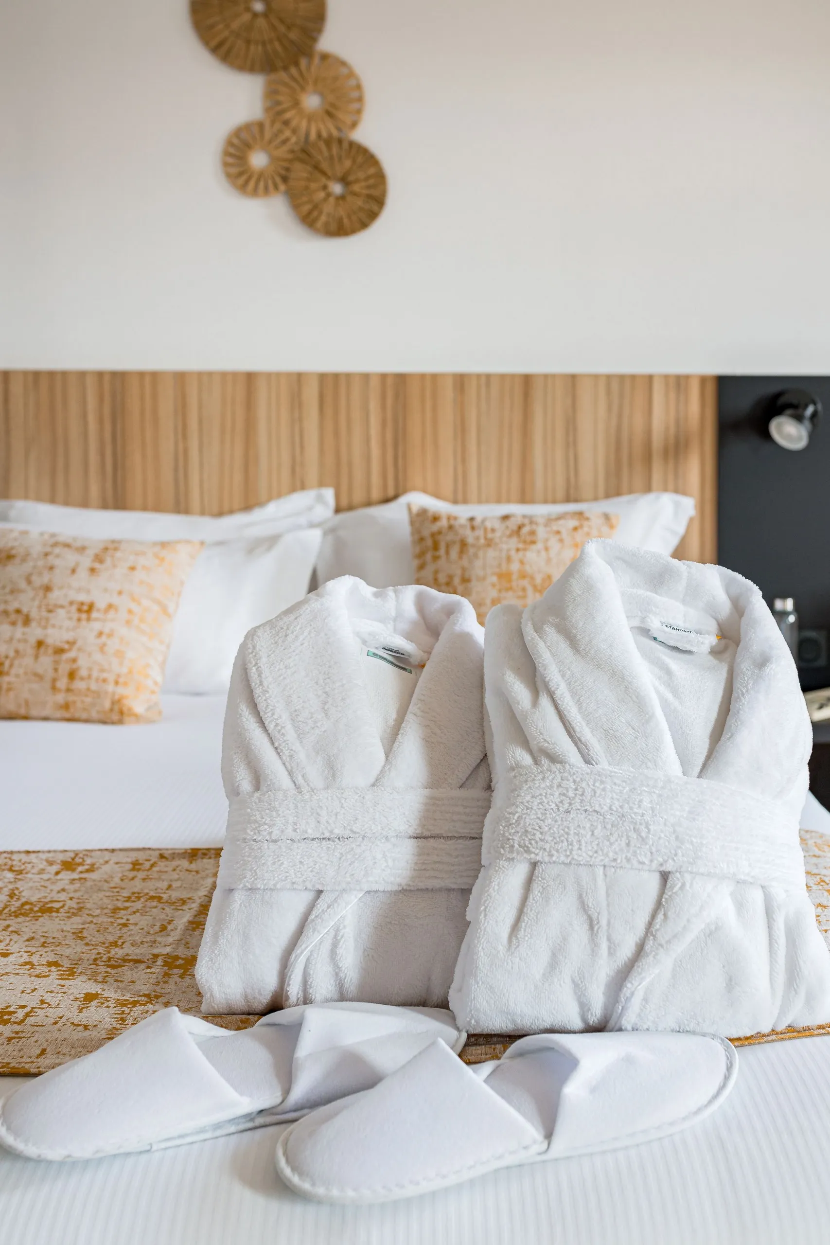 Deux peignoirs blancs sur un lit 