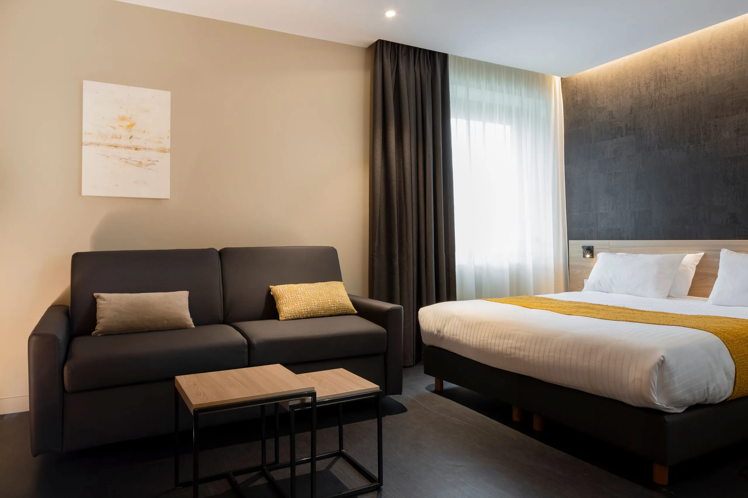 Chambre d'hôtel moderne avec canapé et lit double 